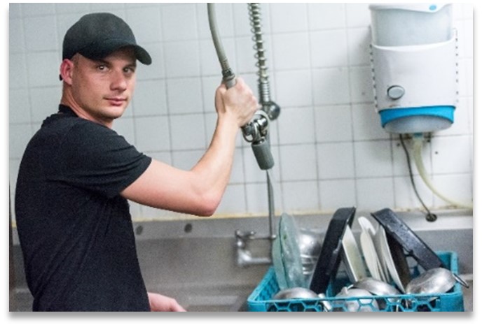 Man washing dishes in restaurant
